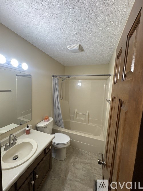 A bathroom with a toilet, sink, and bathtub.