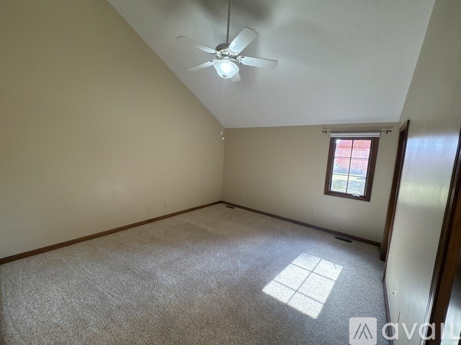 A room with a ceiling fan and a window.
