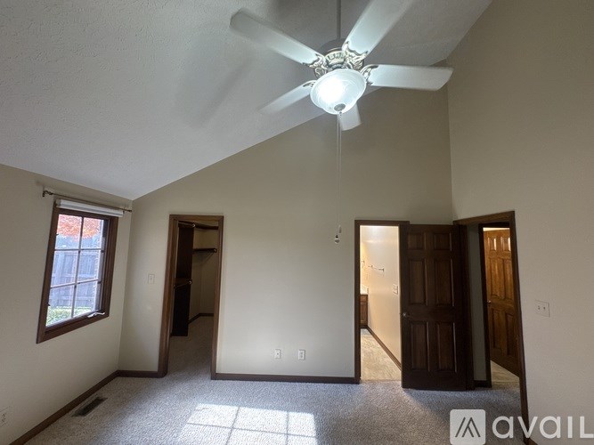 A room with a ceiling fan and a window.