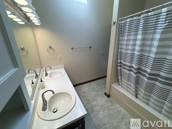 A bathroom with a sink, mirror, and shower curtain.
