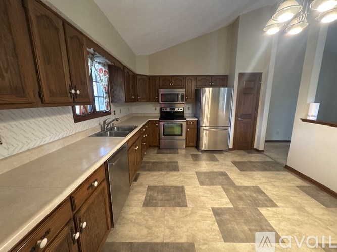 A kitchen with wooden cabinets and a tile floor.