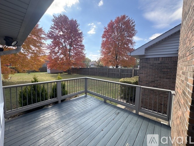 A deck with a railing and trees in the background.