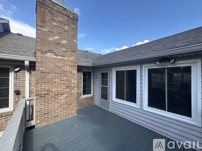 A balcony with a brick chimney and sliding glass doors.