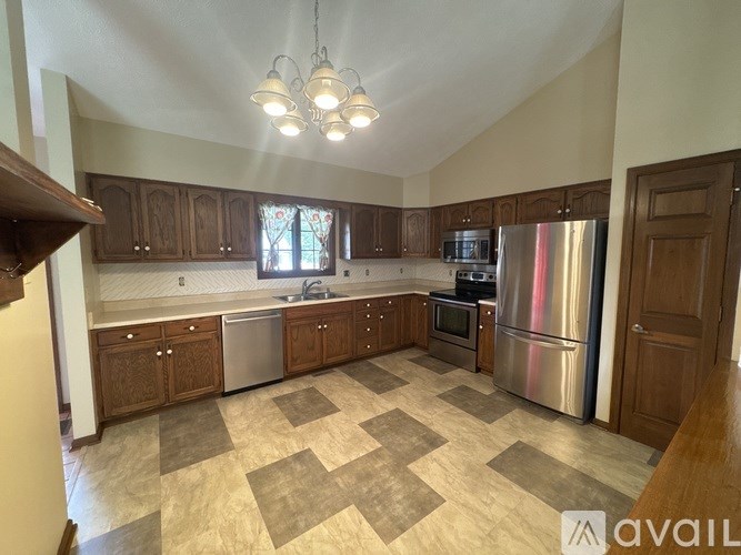 A kitchen with wooden cabinets and a checkered floor.