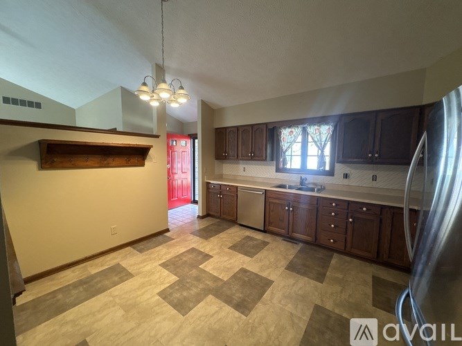 A kitchen with wooden cabinets and a checkered floor.
