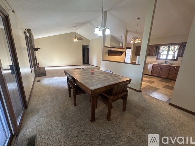 A spacious room with a wooden table and chairs in the center.