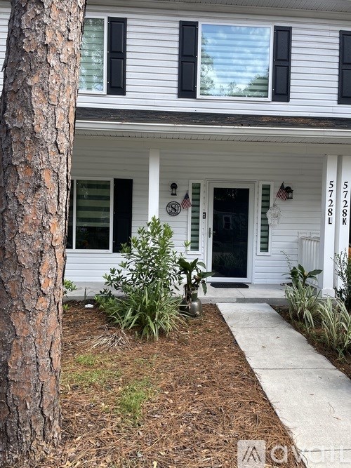 A white house with a black door and windows.