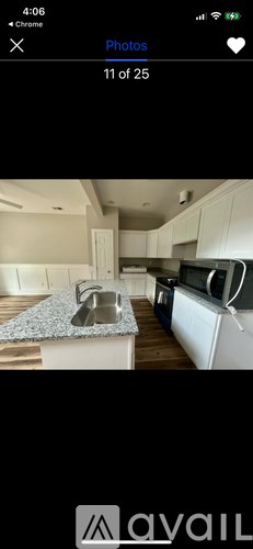 A kitchen with a granite countertop and white cabinets.