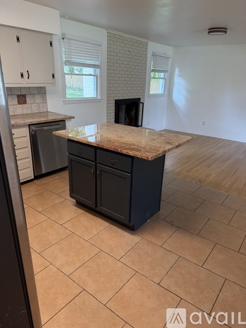 A kitchen with a black dishwasher and a wooden island.
