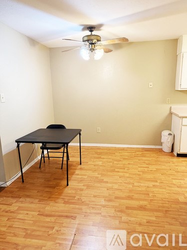 A room with a table and a fan.