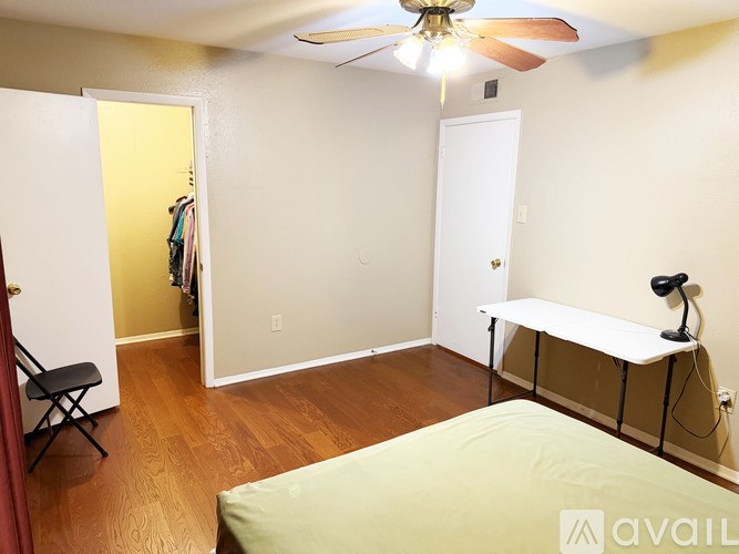 A room with a ceiling fan and a bed.