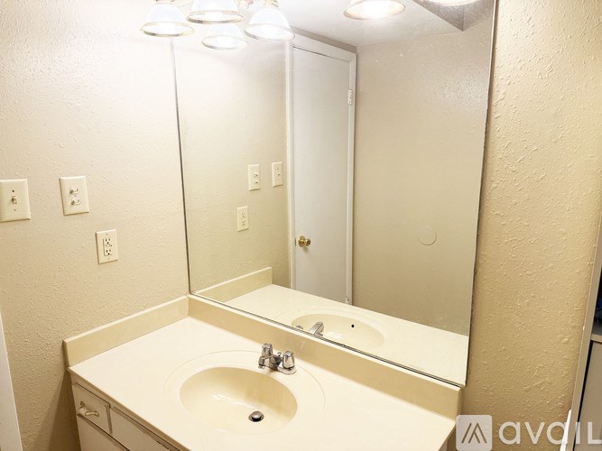 A bathroom with a sink, mirror, and lights.
