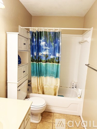 A bathroom with a toilet, sink, and shower curtain.