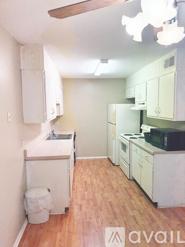 A kitchen with wooden floors and white appliances.