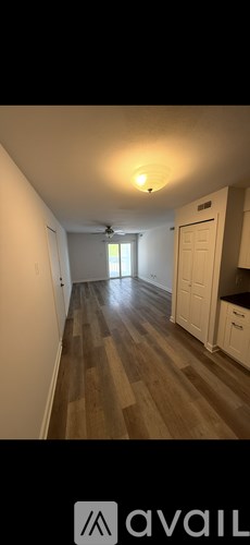 A long hallway with wood floors and white walls.