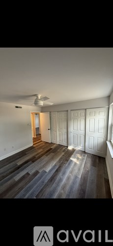 A room with wooden flooring and a ceiling fan.