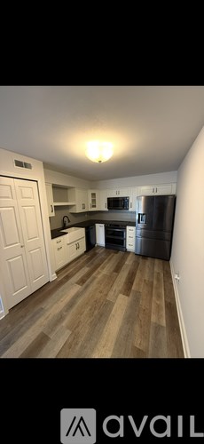 A kitchen with wooden floors and white walls.