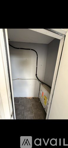 A small, empty room with a black pipe running along the wall.