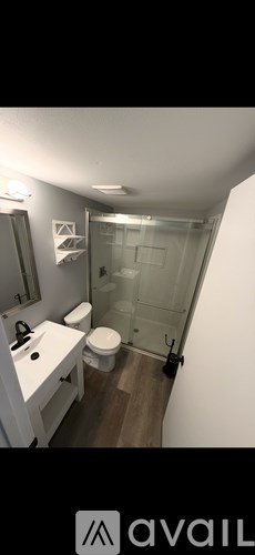 A bathroom with a toilet, sink, and shower.