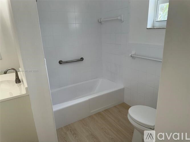 A white bathroom with a tub, toilet and sink.