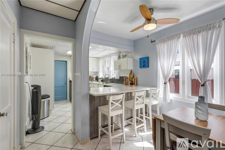 A kitchen with white chairs and a blue door.