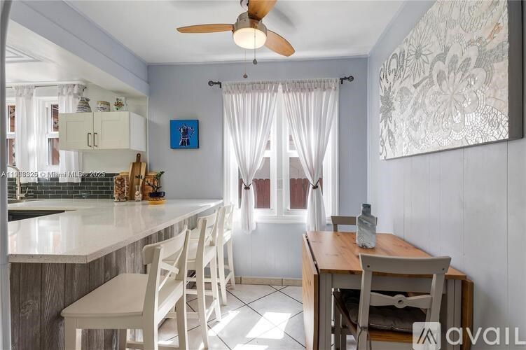 A kitchen with a table and chairs in front of a window.