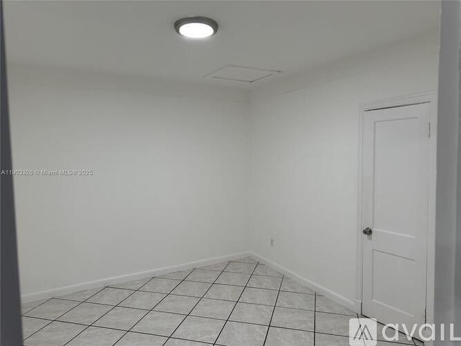 A white room with a door and tiled floor.