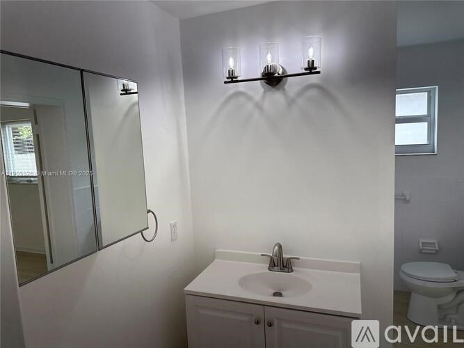 A bathroom with a sink, mirror, and toilet.