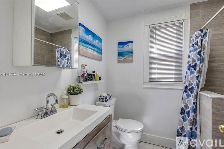 A bathroom with a white sink, toilet, and a blue and white shower curtain.