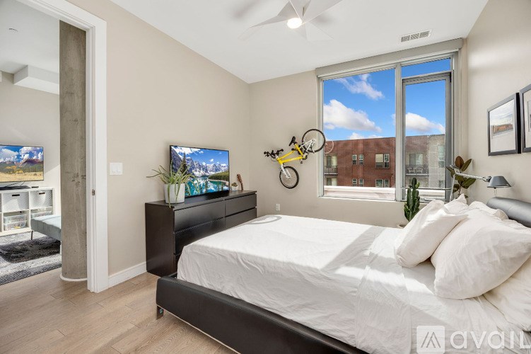 A bedroom with a large bed, a flat screen TV, and a bicycle decoration on the wall.