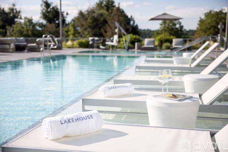 A poolside lounge area with a towel reading Lakehouse.