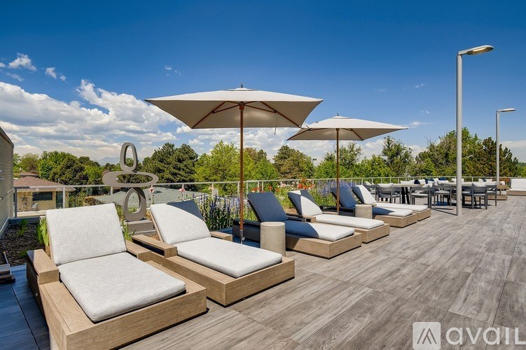 A sunny day at the outdoor seating area with white cushioned chairs and umbrellas.