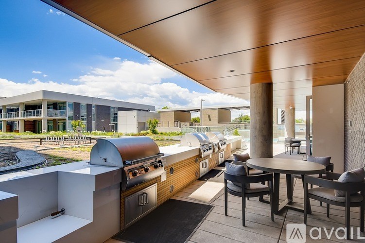 A modern outdoor kitchen area with a grill and seating area.