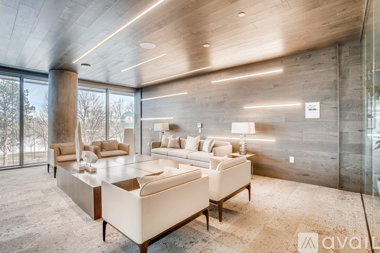 A modern living room with a large window and a wooden ceiling.
