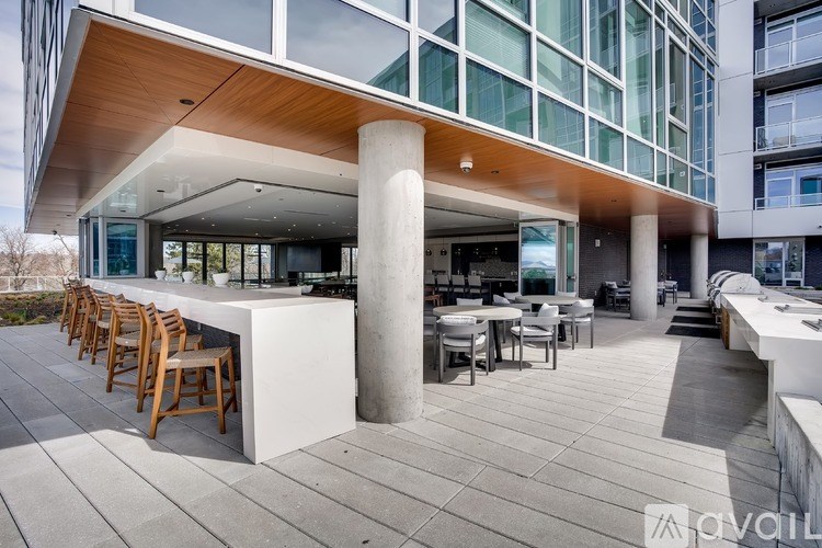 A modern outdoor seating area with wooden chairs and tables.