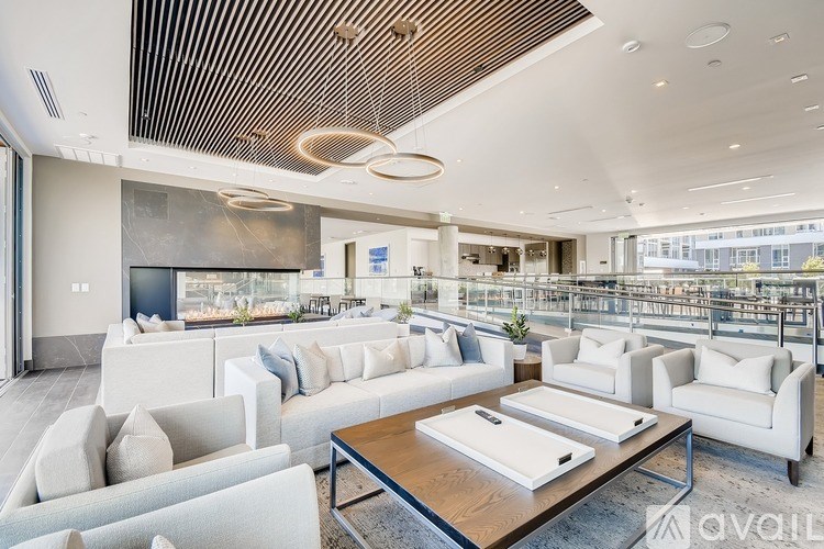 A modern living room with white furniture and a wooden coffee table.