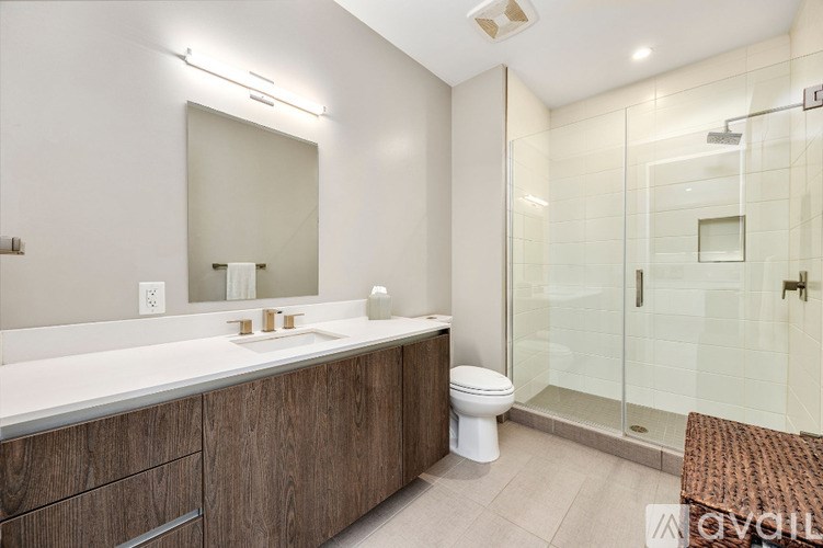 A modern bathroom with a toilet, sink, and shower.