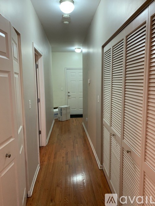 A long hallway with wooden floors and white walls.