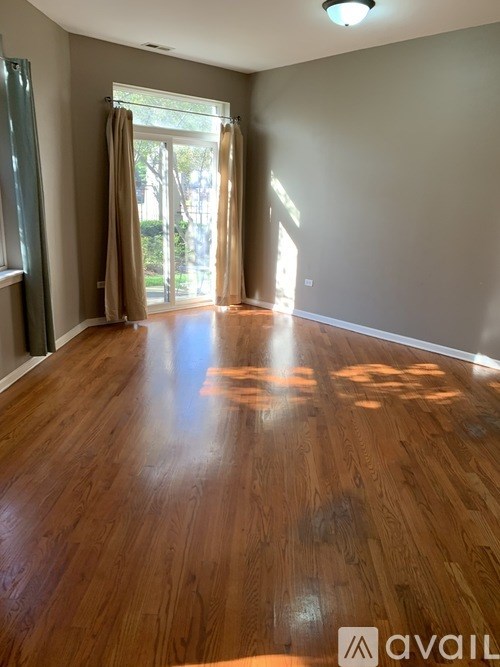 A room with wooden flooring and a sliding glass door.