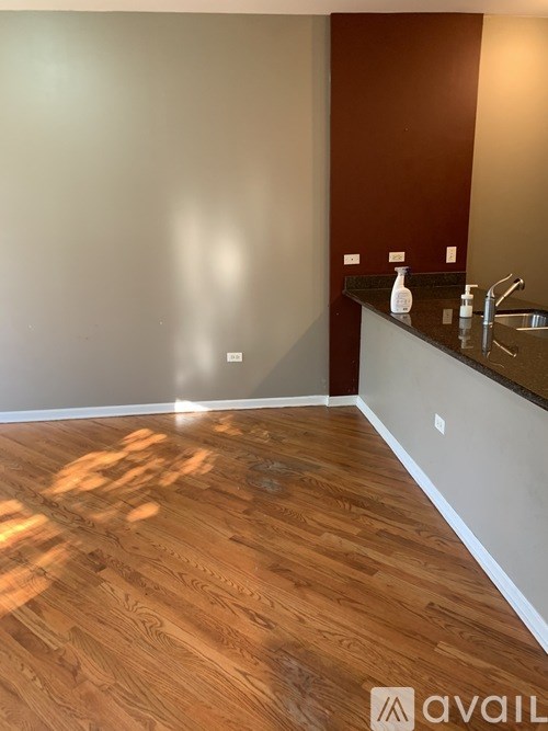 A bathroom with a brown counter and wooden floor.