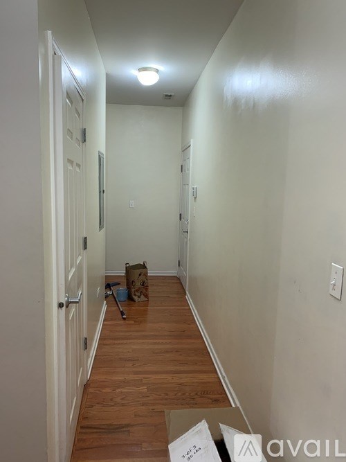A long, narrow hallway with a brown bag on the floor.