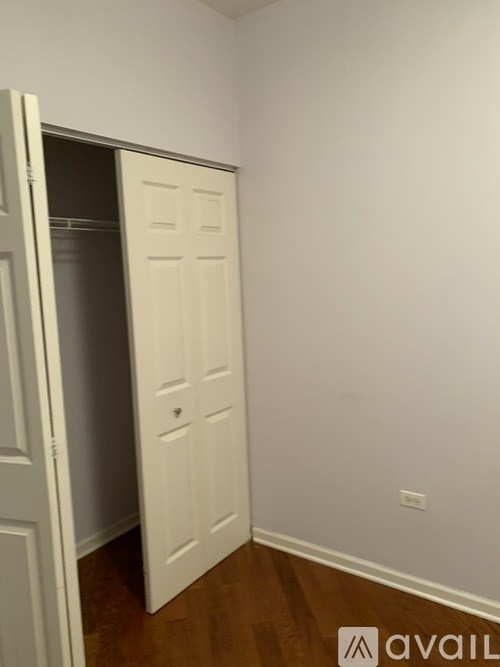 A white door is open to a small room.