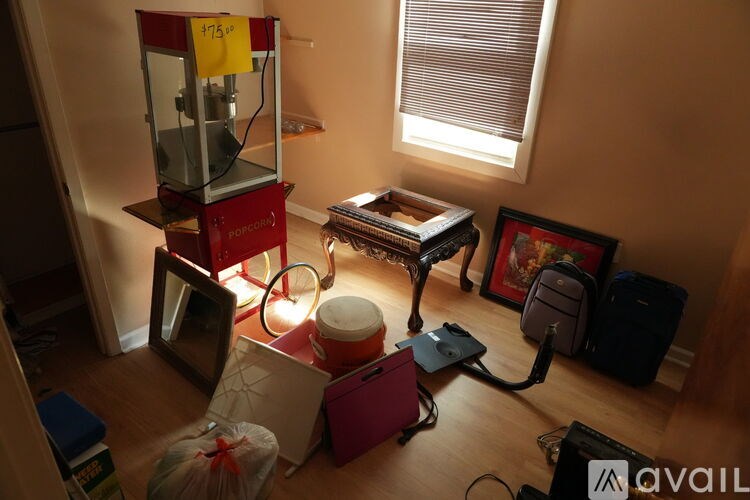 A room with a red machine and a bag on the floor.