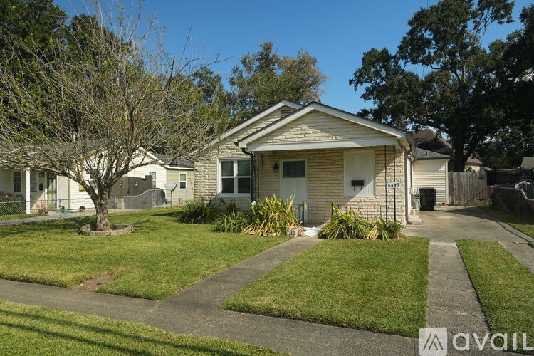 A house with a front yard and a tree.