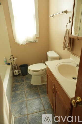 A bathroom with a toilet, sink, and tub.