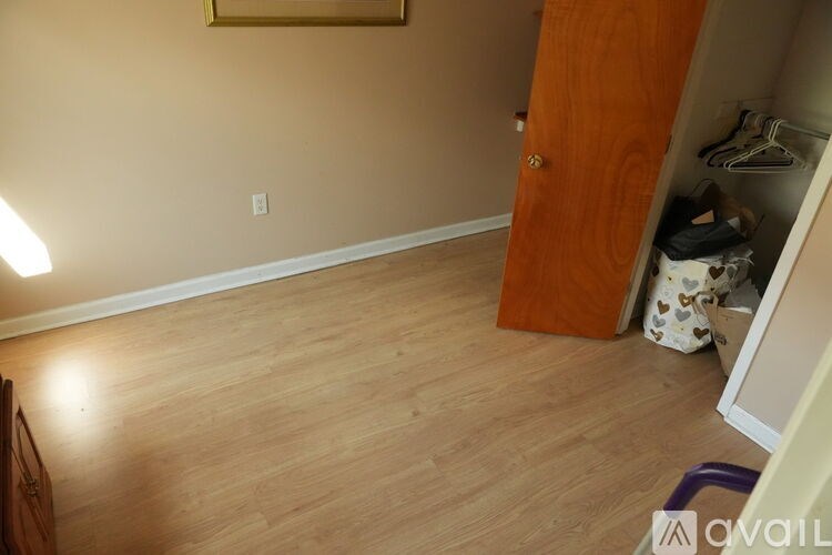A room with a wooden floor and a door leading to a closet.