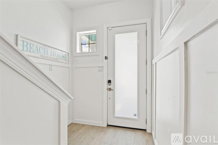 A white door with a glass window is in a hallway.
