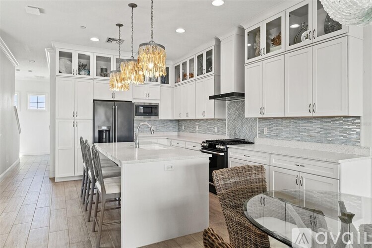 A modern kitchen with white cabinets and a central island.