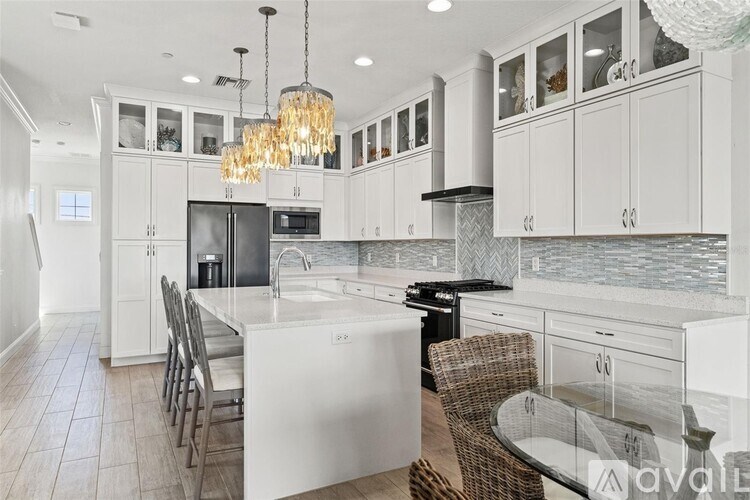 A modern kitchen with white cabinets and a central island.