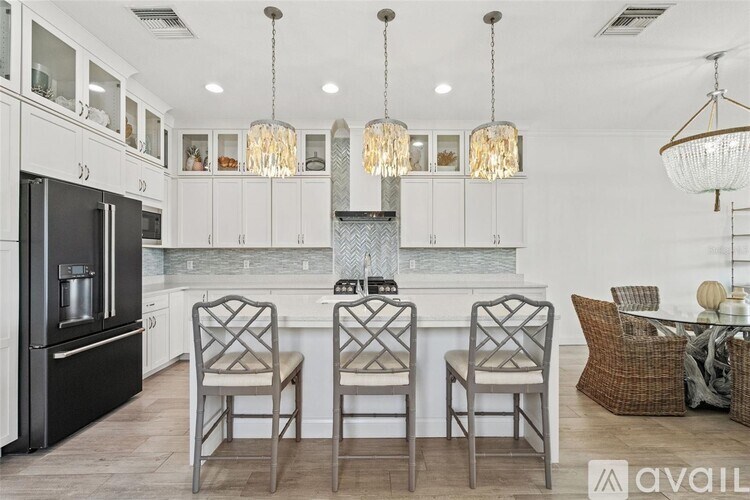 A modern kitchen with a center island and chairs.